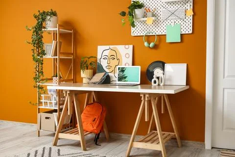 Interior of stylish office with workplace, shelf unit and pegboard Stock Photos