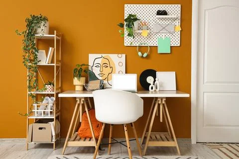 Interior of stylish office with workplace, shelf unit and pegboard Stock Photos