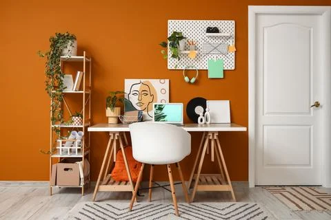 Interior of stylish office with workplace, shelf unit and pegboard Stock Photos