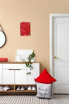 Interior of stylish room with commode, basket and door Stock Photos