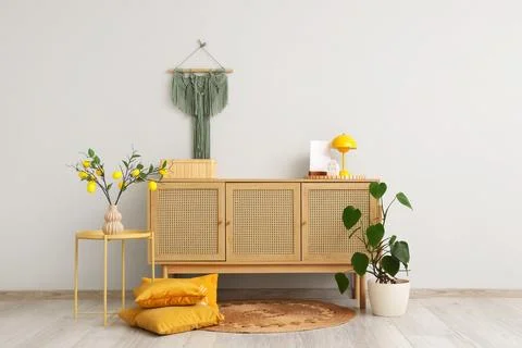 Interior of stylish room with commode, table and lemon tree branches Stock-Fotos