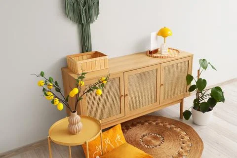 Interior of stylish room with commode, table and lemon tree branches Stock-Fotos