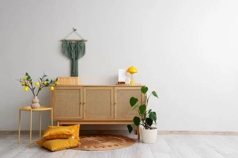 Interior of stylish room with commode, table and lemon tree branches Stock-Fotos