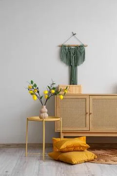 Interior of stylish room with commode, table and lemon tree branches Stock-Fotos
