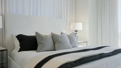 Interior of stylish suite with made double bed with soft headboard between Stock Footage 265173334
