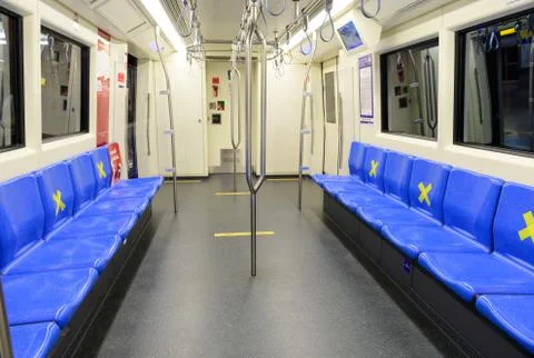 Interior of subway train with empty seats with signs social distancing protect Stock Photos