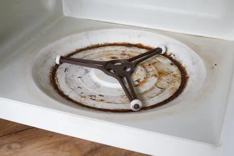 Interior surface of the microwave's bottom panel is covered in rust and rot. Stock Photos