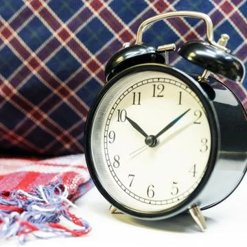 Interior tartan and table clock next to pillows with checkered pattern Stock Photos