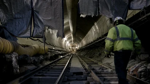Interior Tunnel Construction Worker walking in from Camera Right Stock Footage 89980666
