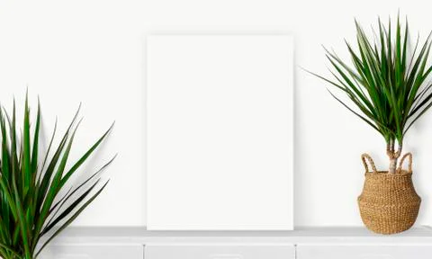 Interior vertical rectangular poster mockup standing on the table with plant  Stock Photos