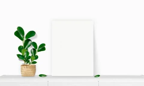 Interior vertical rectangular poster mockup standing on the table with plant  Stock Photos
