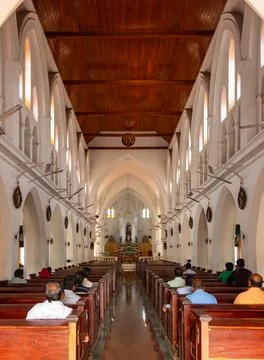 Interior Vertical Shot of Devotees Praying Inside a Catholic Church Stock Photos