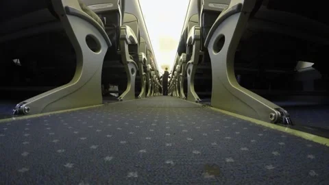 Interior view of airplane aisle showcasing rows of seats and patterned carpet Stock Footage 319527579