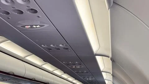 Interior view of airplane cabin ceiling with overhead aisle lights and cont.. Stock Photos