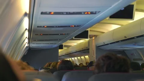 Interior view of an airplane cabin with passengers seated and overhead comp.. Stock Footage 282023743