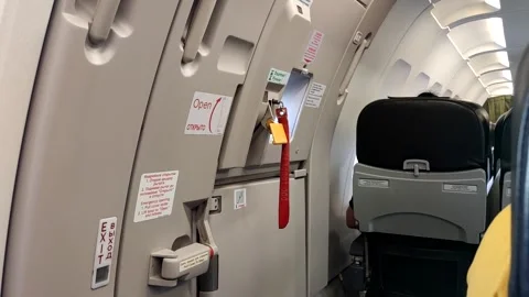 Interior view of airplane emergency exit door and seating area Stock-Footage 297874100