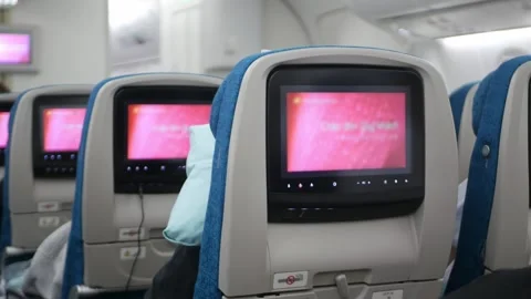 Interior view to airplane seat with personal screen entertainment on every .. Видео 337008537