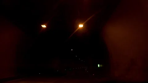 Interior view of a brightly lit road tunnel with an arched ceiling and Vidéo 281017937