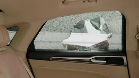 Interior view of car hole in smashed side window vandalism auto theft crime Stock Footage 275740434