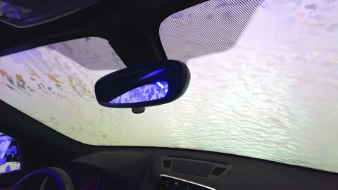 Interior view of a car windshield covered in soapy water during a car wash Stock Footage 280085339