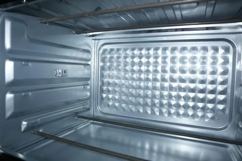 Interior view of a clean, empty electric oven with metal heating elements, .. Stock Photos