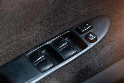 Interior view with drivers door, window buttons and armrest of black and gray Stock Photos