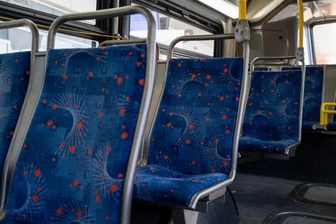 Interior view of empty bus seats with patterned fabric Photos