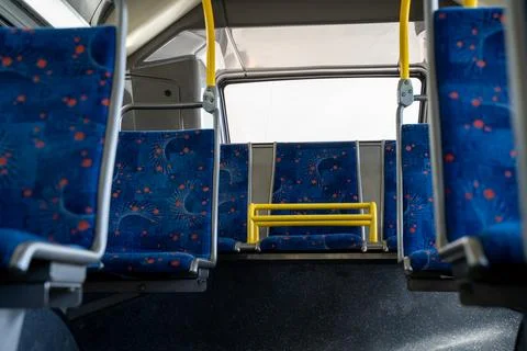 Interior view of empty bus seats with patterned fabric Photos