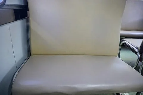 Interior view of an empty economy class train carriage with brown faux leather Stock Photos