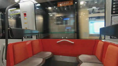 Interior view of an empty metro train car at a station with vibrant orange seats Stock Footage 294909820