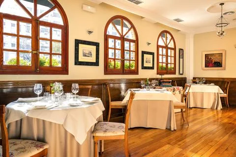 Interior view of an empty restaurant with tables set. Stock Photos