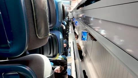 Interior view of a Eurostar train featuring blue seating overhead luggage Vídeo Stock 331055322