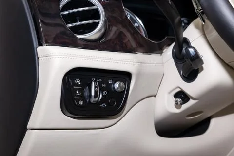 Interior view with headlight switch button and white leather control panel, b Stock Photos