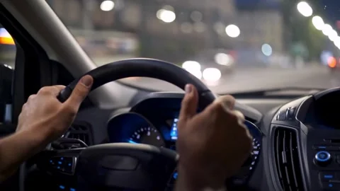 Interior view of male hand on steering wheel in car at night. Road trip, Stock-Footage 336265847