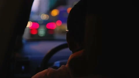 Interior view of a man driving his private taxi through the city streets at Stock Footage 200975109