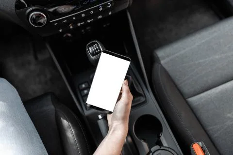 Interior view of a modern new car. A young woman using smartphone while drivi Stock Photos