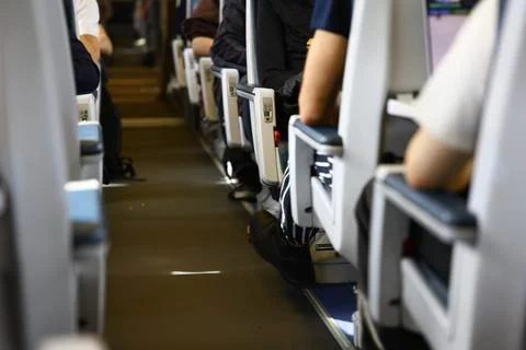 Interior view of a modern passenger train with travelers seated during a jour Foto stock