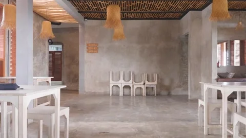 Interior view of a modern restaurant with concrete walls and white furniture. 库存影片 343413133