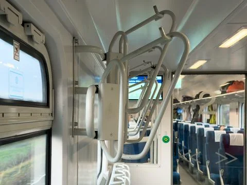 Interior view of a modern train car featuring luggage racks, comfortable se.. Stock Photos