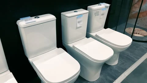 Interior View: Modern White Floor-Mounted Toilets Display in Plumbing Store Show Stock Footage 328336084