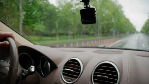 Interior view from a moving vehicle with windshield wipers clearing rainwater Stock Footage 336909138