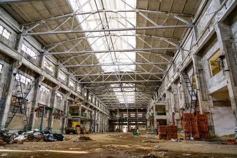 Interior view of an old abandoned workshop with piles of building materials Stock Photos