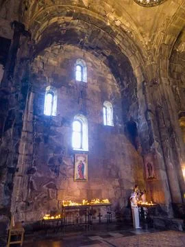 Interior view of old Armenian Tatev monastery with arched ceiling and lit Stock Photos