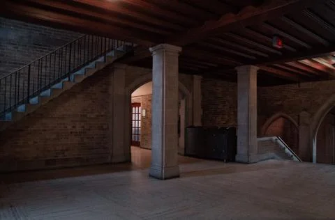 Interior view of an old building with columns and stairway with some light beams Stock Photos