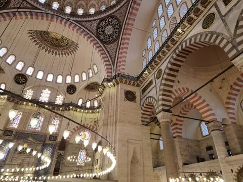 Interior view of ornate mosque hall with arches and stained glass Фото