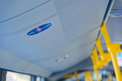 Interior view of a public bus ceiling with blue emergency hammer sign and y.. Photos