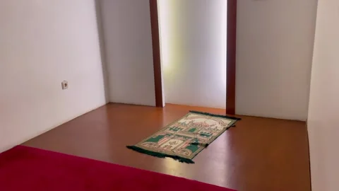 Interior view of small prayer room with prayer mat Stock-Footage 346553806