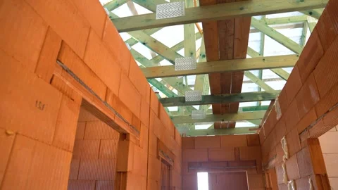 Interior view of unfinished brick walls and exposed impregnated roof trusses in Stock Footage 310997519