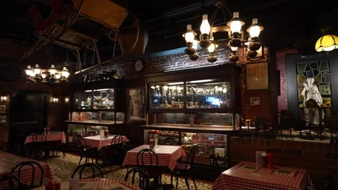 Interior of a vintage restaurant with red checkered tablecloths and brick walls Stock Footage 336350091