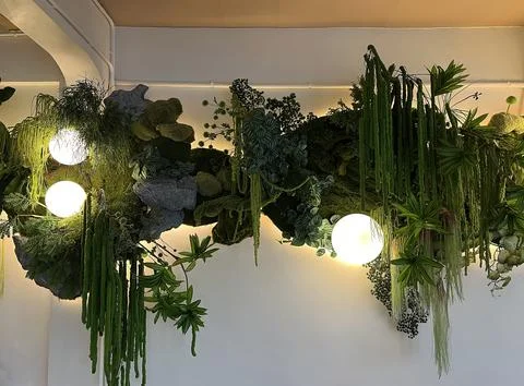 Interior wall decoration featuring artificial green and round lamps Stock Photos